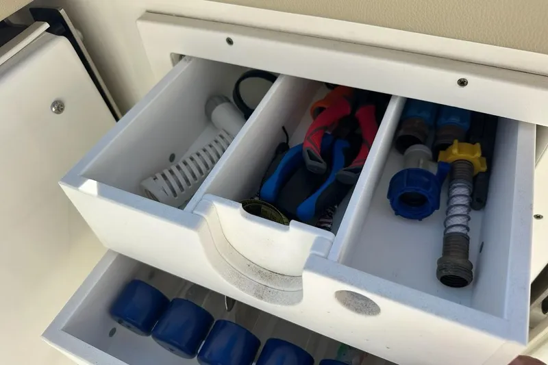 Slide: The Image of Storage compartment with tools and accessories on a 2020 Pursuit OS 355 Offshore boat. - 45