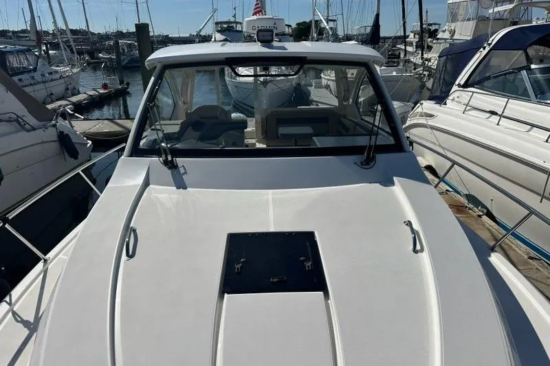 Slide: The Image of 2020 Pursuit OS 355 Offshore boat docked at a marina, surrounded by other vessels. - 51