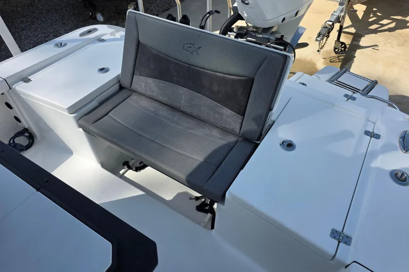 Slide: The Image of 2021 Crevalle 24 HCO boat seating area with gray cushioned bench and storage compartments. - 18
