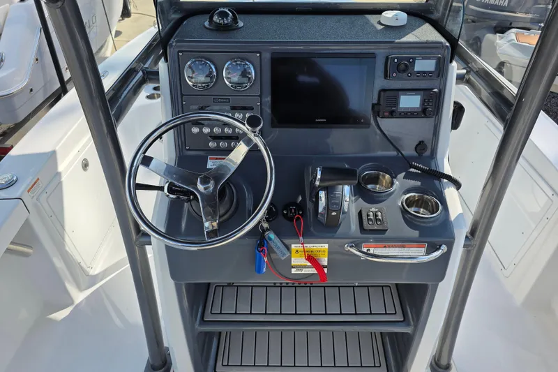 Slide: The Image of 2021 Crevalle 24 HCO boat console with steering wheel, gauges, and navigation equipment. - 23