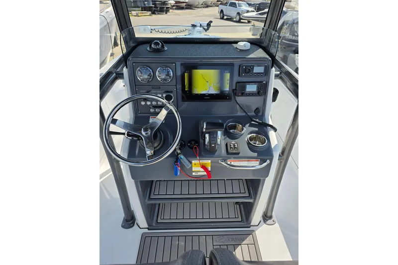 Slide: The Image of 2021 Crevalle 24 HCO boat dashboard with steering wheel and navigation system. - 24