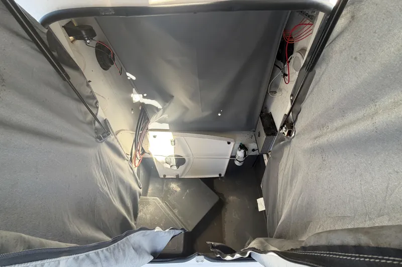 Slide: The Image of Interior view of 2022 Yamaha Boats 252 FSH Sport, showcasing storage and wiring. - 16