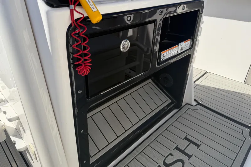 Slide: The Image of 2022 Yamaha Boats 252 FSH Sport interior storage compartment with safety lanyard. - 23