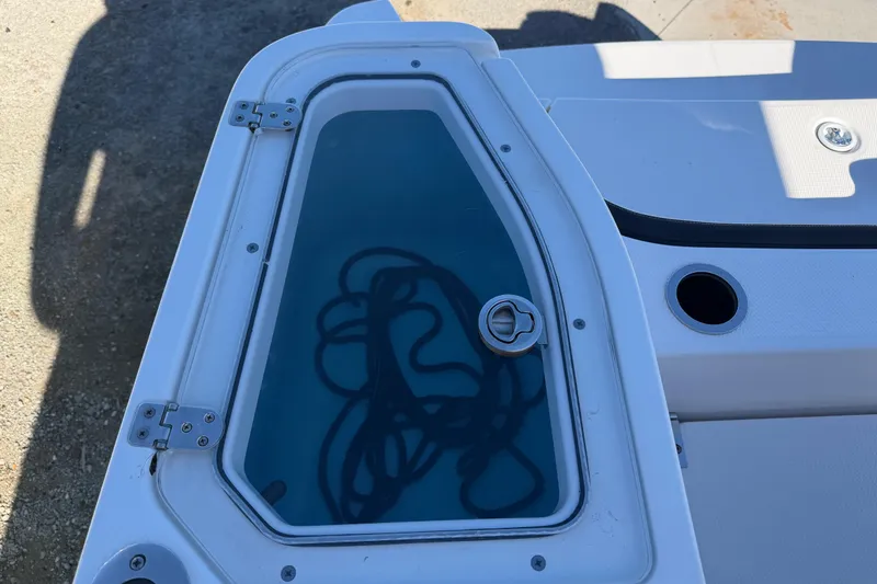 Slide: The Image of 2022 Yamaha Boats 252 FSH Sport storage compartment with visible rope inside. - 30