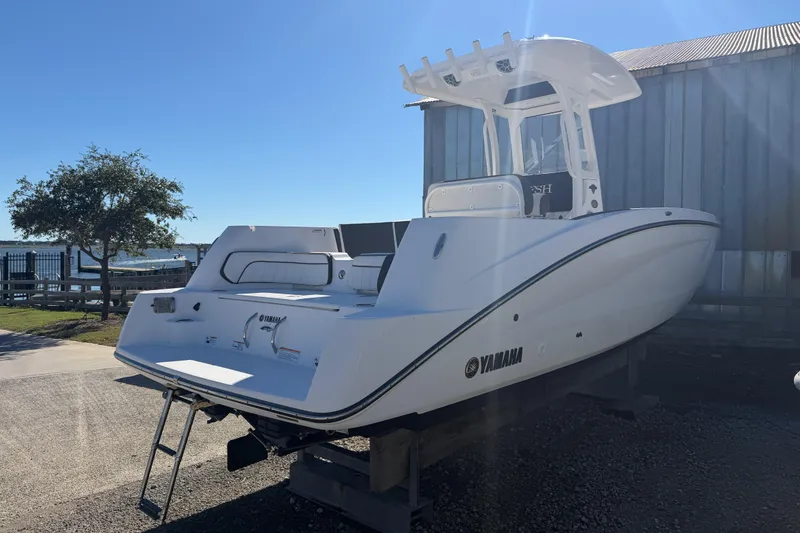 Slide: The Image of 2022 Yamaha Boats 252 FSH Sport, white, docked outdoors under clear blue sky. - 4