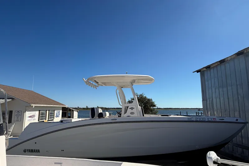 Slide: The Image of 2022 Yamaha Boats 252 FSH Sport docked near a bait shop under clear blue sky. - 5