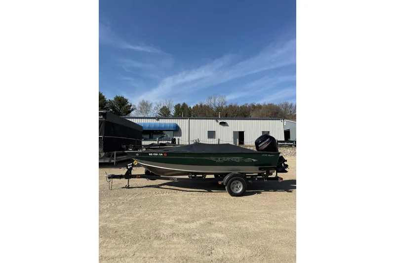Slide: The Image of 2017 Lund 1775 Impact SS boat on trailer, parked outdoors under clear blue sky. - 16