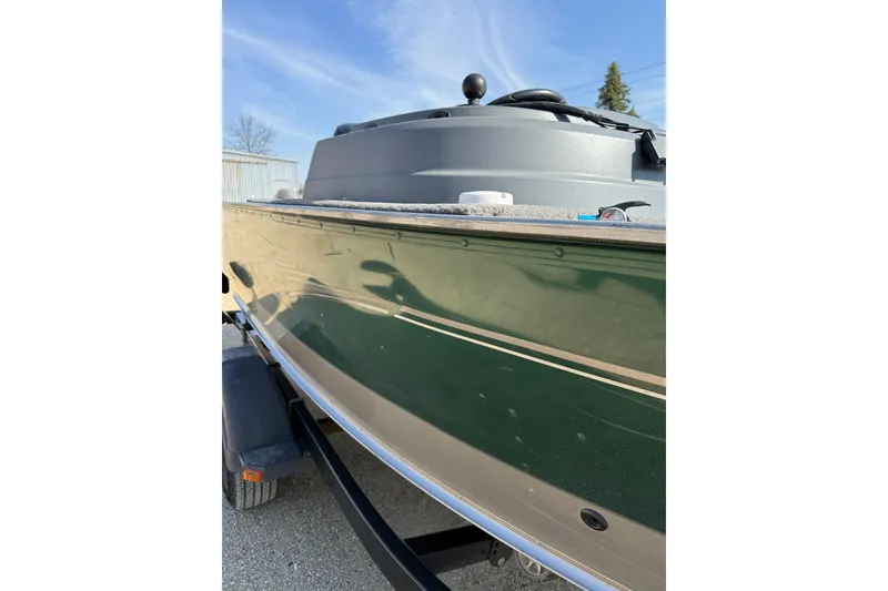 Slide: The Image of 2017 Lund 1775 Impact SS boat side view, green hull, parked on trailer. - 18