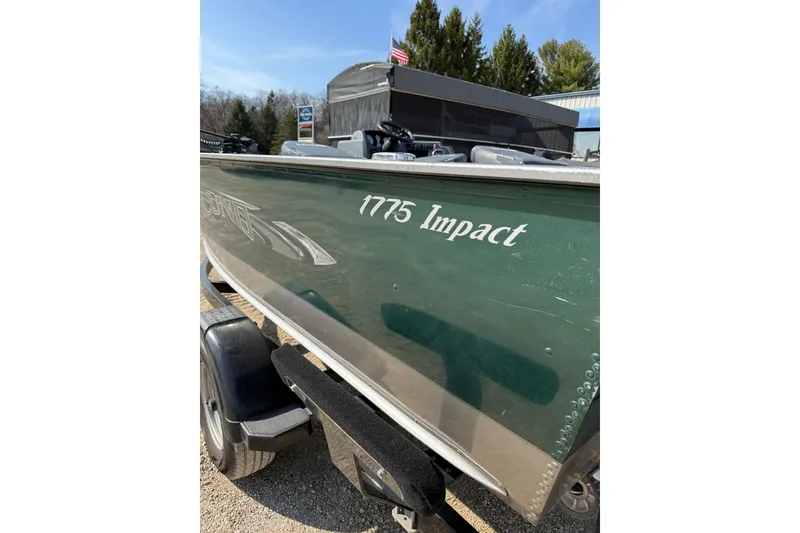 Slide: The Image of 2017 Lund 1775 Impact SS boat on trailer, green exterior, parked outdoors. - 21