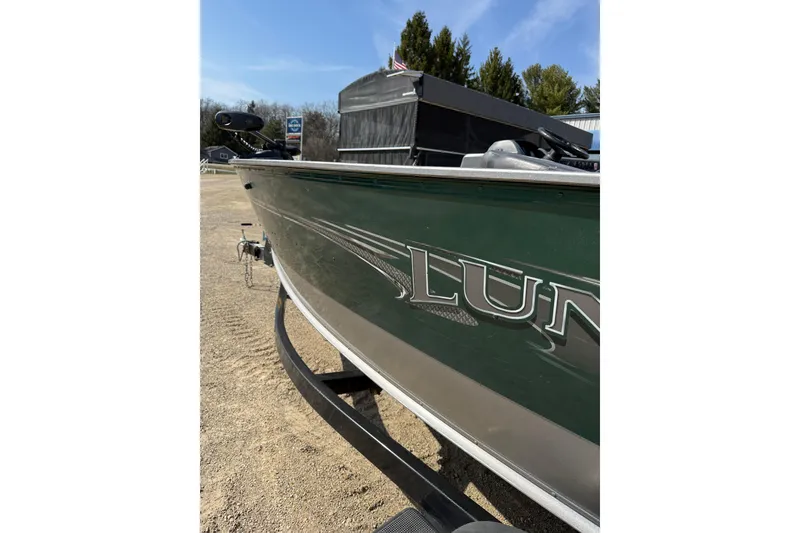 Slide: The Image of 2017 Lund 1775 Impact SS boat in green, parked on a trailer, sunny day. - 22
