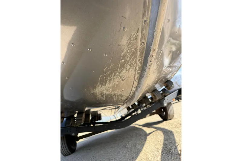 Slide: The Image of 2017 Lund 1775 Impact SS boat hull with visible scratches on trailer. - 25