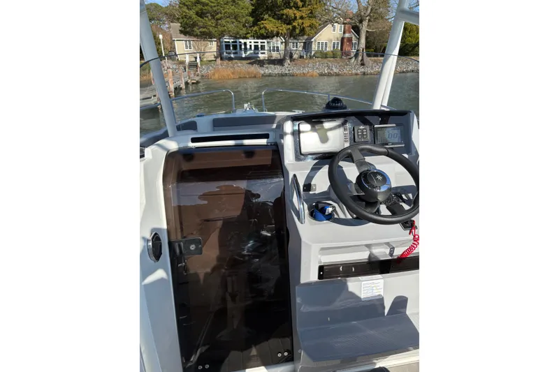 Slide: The Image of 2023 Jeanneau Leader 6.5 CC Series 3 helm with steering wheel and controls. - 2