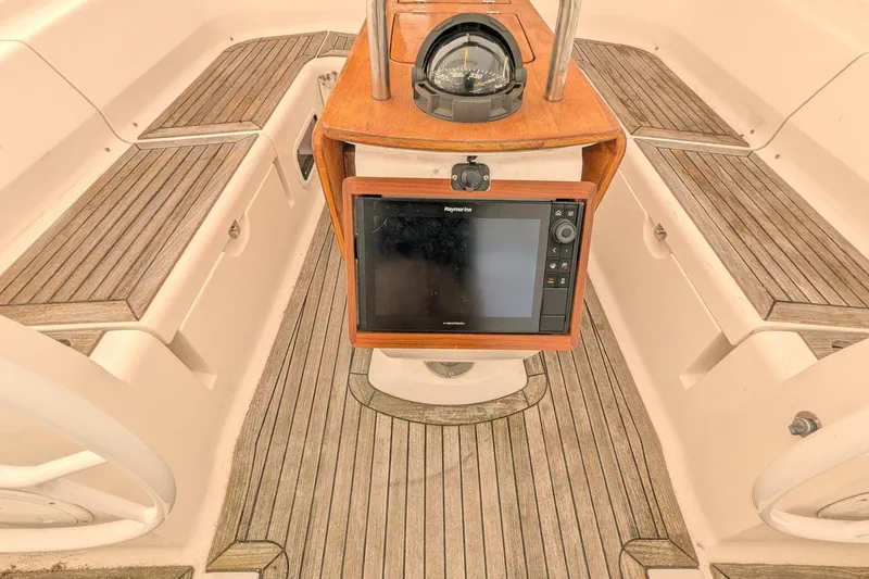 Slide: The Image of Cockpit of 2007 Elan Impression 434 sailboat with navigation equipment and wooden seating. - 2