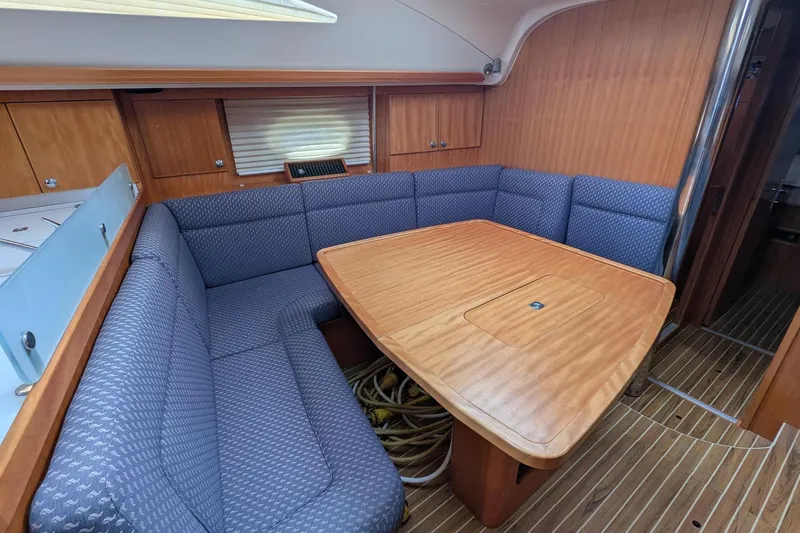 Slide: The Image of Interior of 2007 Elan Impression 434 yacht with wooden table and blue cushioned seating. - 27