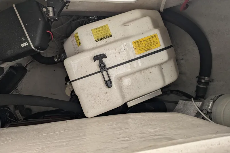 Slide: The Image of Engine compartment of a 2007 Elan Impression 434 sailboat, featuring a white tank and hoses. - 34