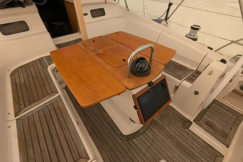 Slide: The Image of Cockpit of 2007 Elan Impression 434 sailboat with wooden table and navigation equipment. - 4