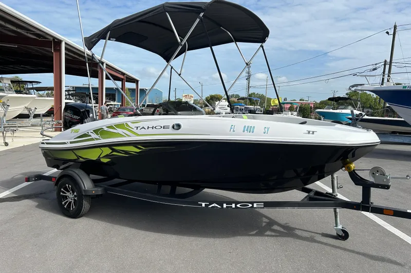 The Image of 2021 Tahoe T16 boat with canopy on trailer in marina setting. - 1
