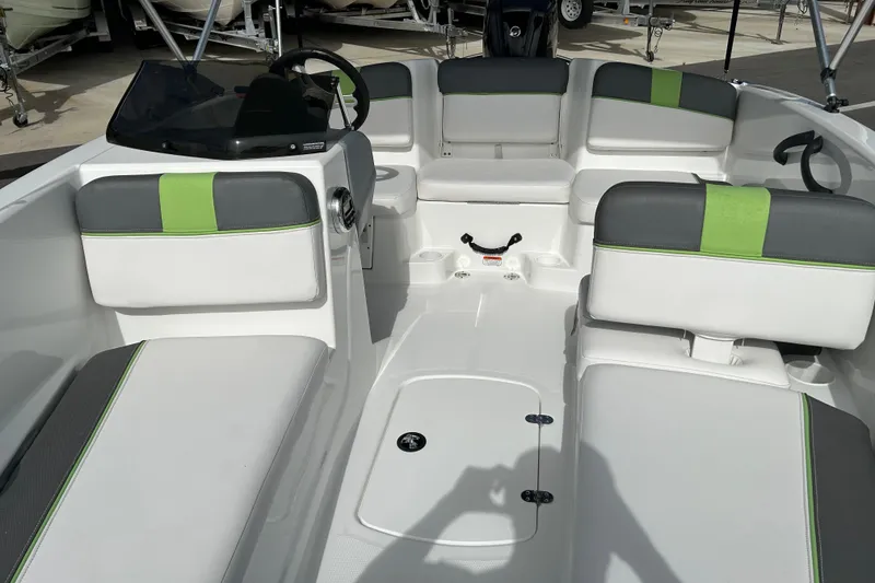 Slide: The Image of 2021 Tahoe T16 boat interior with gray and green seating, steering wheel, and storage compartments. - 9