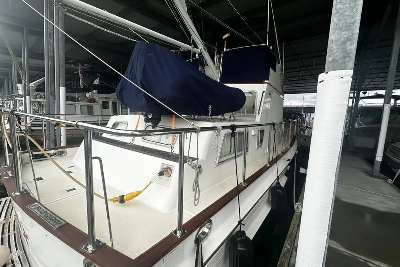The Image of 2000 Island Gypsy 36 yacht docked in a covered marina, featuring a sleek design. - 0
