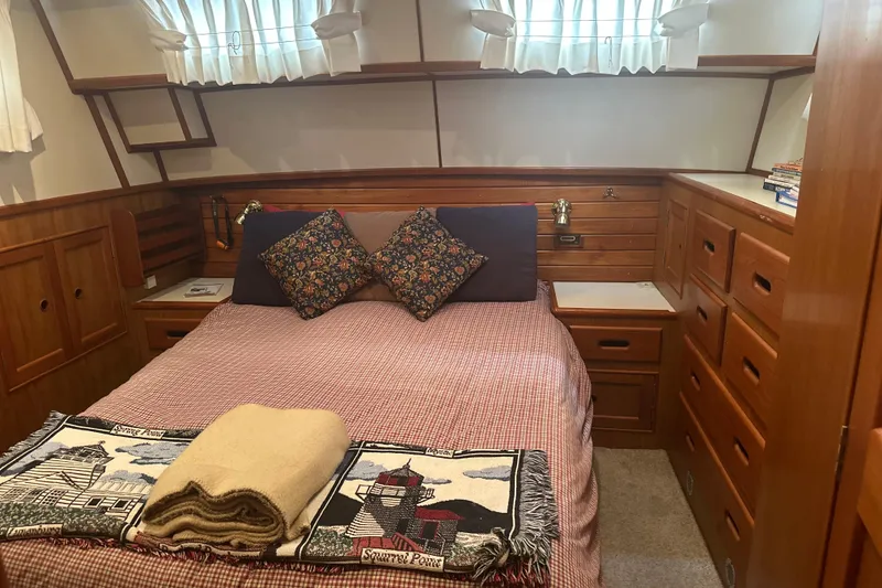 Slide: The Image of Cozy cabin bedroom in 2000 Island Gypsy 36 yacht with wooden storage and decorative pillows. - 10