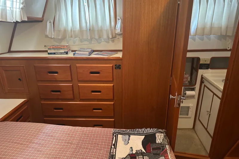Slide: The Image of Cozy cabin interior of 2000 Island Gypsy 36 with wooden drawers and books. - 11