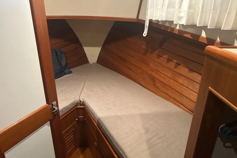 Slide: The Image of Cozy cabin interior of 2000 Island Gypsy 36 with wooden paneling and cushioned berth. - 14