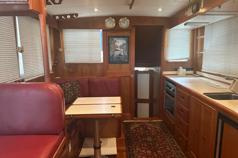 Slide: The Image of Interior of 2000 Island Gypsy 36 yacht with wood finish and red seating. - 4