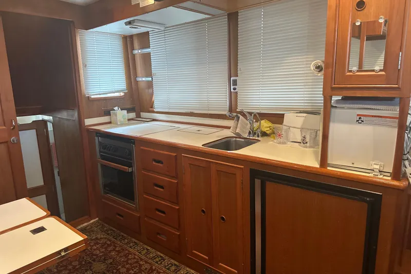 Slide: The Image of Interior of 2000 Island Gypsy 36 yacht kitchen with wood cabinetry and appliances. - 6