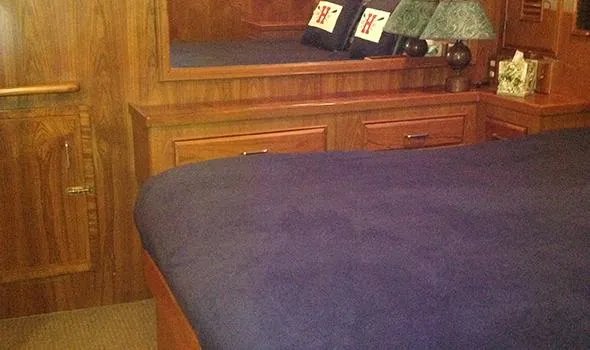 Slide: The Image of Cozy cabin interior of 1986 Sea Ranger 47 Pilothouse with wooden furnishings and blue bedding. - 14