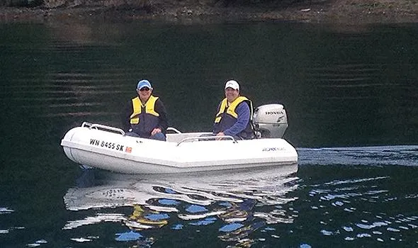 Slide: The Image of Two people in a small boat on calm water, wearing life jackets. - 15