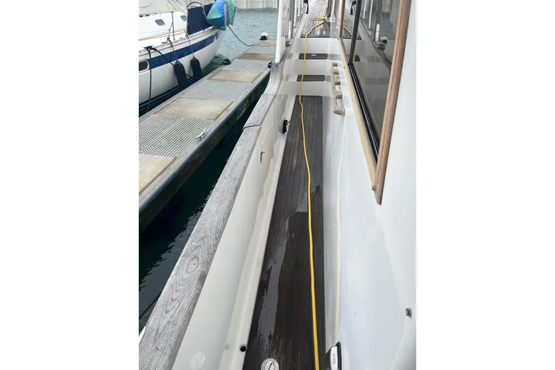 Slide: The Image of Sea Ranger 47 Pilothouse 1986 docked, showing side deck and marina view. - 17