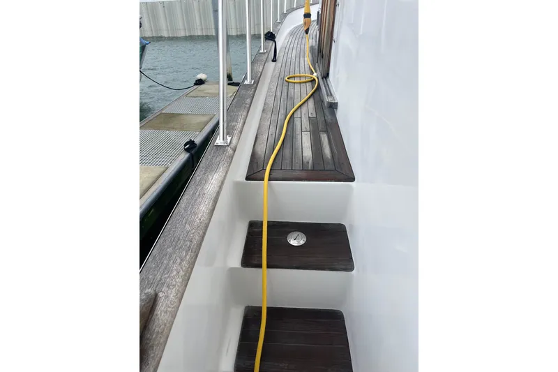 Slide: The Image of 1986 Sea Ranger 47 Pilothouse deck with wooden steps and yellow hose. - 18