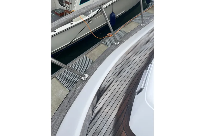 Slide: The Image of 1986 Sea Ranger 47 Pilothouse yacht with wooden deck and metal railing at dock. - 29