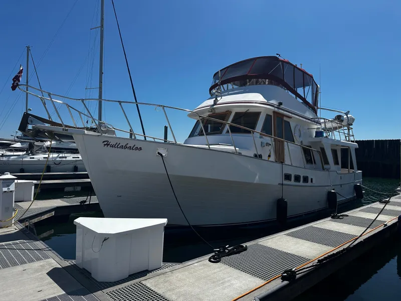 Slide: The Image of 1986 Sea Ranger 47 Pilothouse yacht docked at marina under clear blue sky. - 3