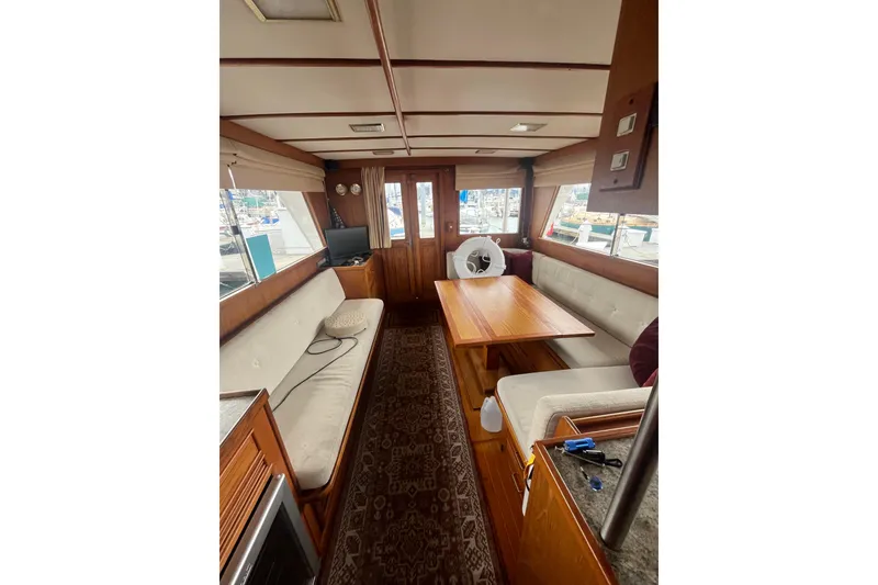 Slide: The Image of Interior of 1986 Sea Ranger 47 Pilothouse with wooden table and cushioned seating. - 33