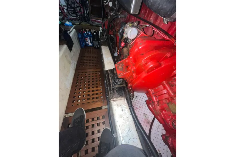 Slide: The Image of Engine room of 1986 Sea Ranger 47 Pilothouse with red machinery and wooden flooring. - 42