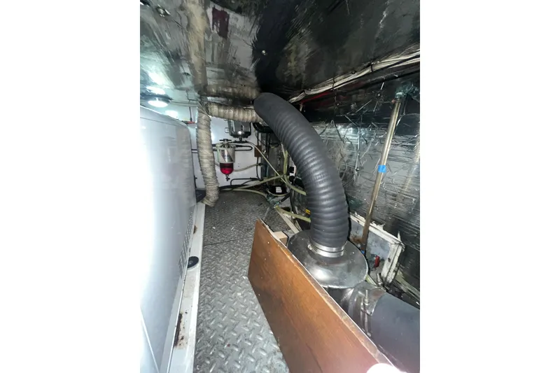 Slide: The Image of Engine room of 1986 Sea Ranger 47 Pilothouse with visible exhaust system and piping. - 44