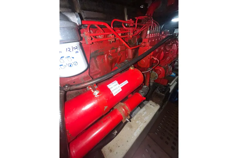 Slide: The Image of Engine compartment of a 1986 Sea Ranger 47 Pilothouse, featuring red machinery components. - 47