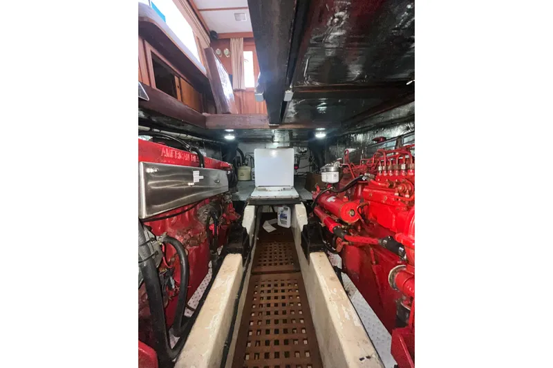 Slide: The Image of Engine room of 1986 Sea Ranger 47 Pilothouse with red machinery and wooden flooring. - 61