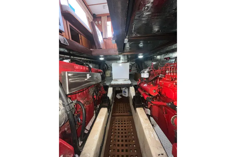 Slide: The Image of Engine room of 1986 Sea Ranger 47 Pilothouse with red machinery and wooden flooring. - 62