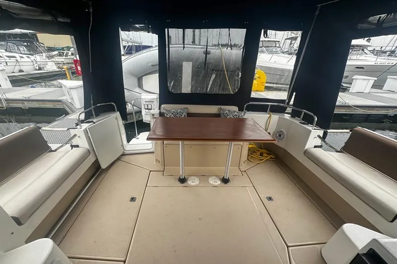 Slide: The Image of 2015 Ranger Tugs R-31 S boat interior with seating and table, docked at marina. - 2