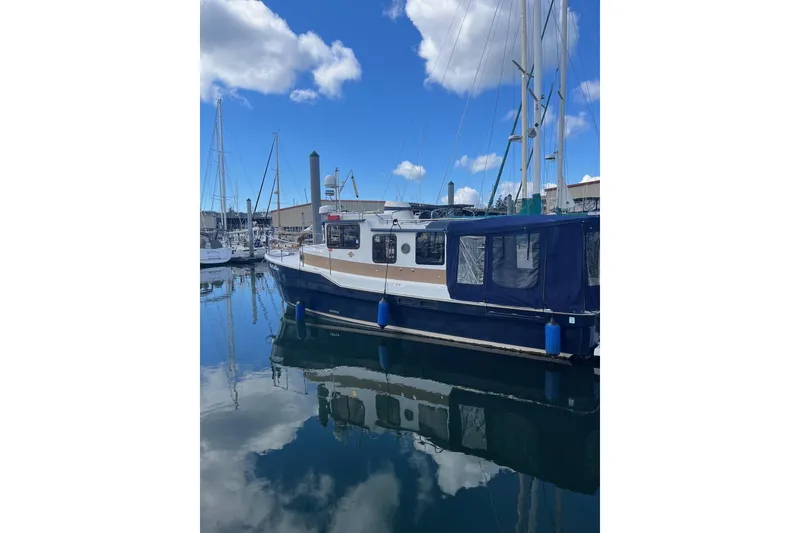 Slide: The Image of 2015 Ranger Tugs R-31 S boat docked in a marina under a blue sky. - 6