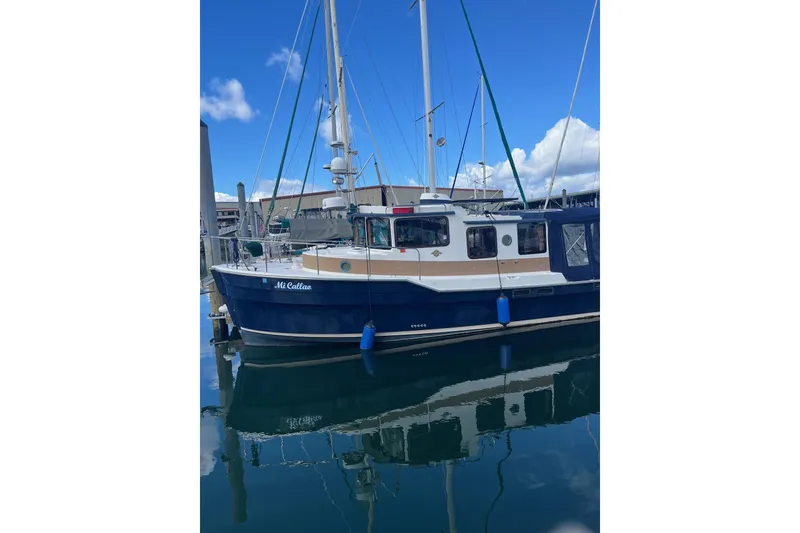Slide: The Image of 2015 Ranger Tugs R-31 S boat docked in marina, reflecting on calm water. - 9