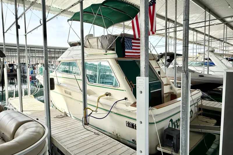 The Image of 1982 Sea Ray 355T Trawler docked in a marina with American flag. - 1