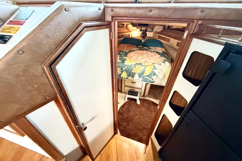 Slide: The Image of 1982 Sea Ray 355T Trawler cabin interior with floral bedding and wooden accents. - 11