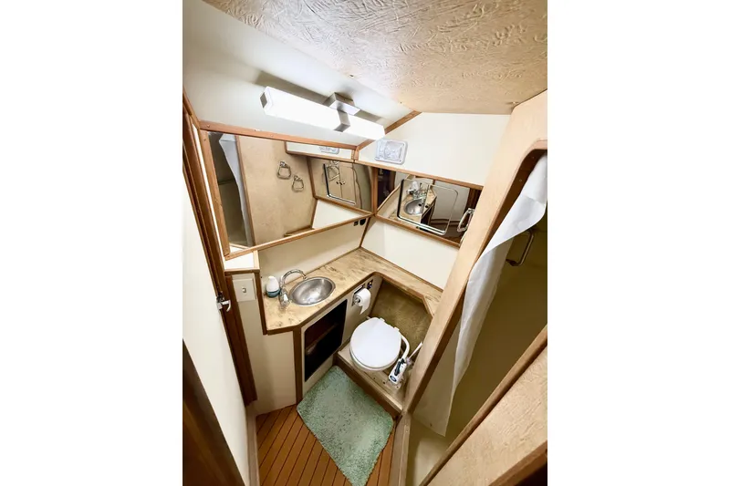 Slide: The Image of 1982 Sea Ray 355T Trawler bathroom with sink, toilet, and mirror. - 12