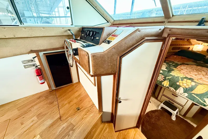 Slide: The Image of 1982 Sea Ray 355T Trawler interior with helm, wooden flooring, and cozy cabin. - 14