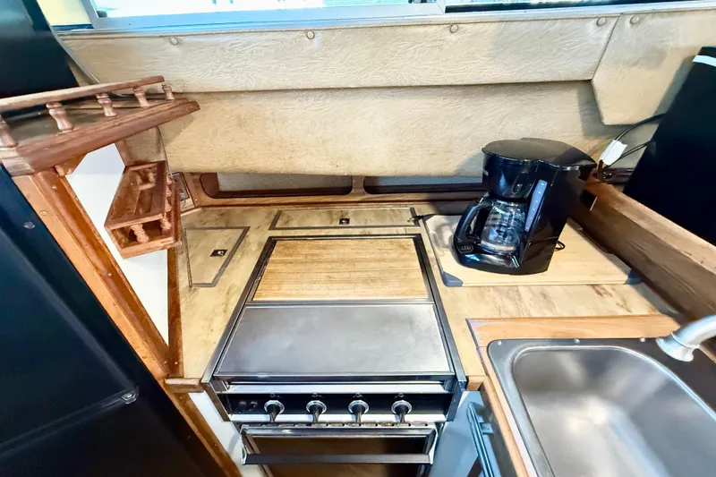 Slide: The Image of 1982 Sea Ray 355T Trawler kitchen with stove, coffee maker, and sink. - 16