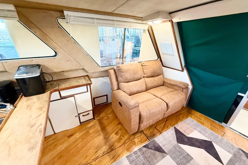 Slide: The Image of Interior of 1982 Sea Ray 355T Trawler with cozy seating and wooden flooring. - 17