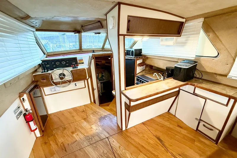 Slide: The Image of 1982 Sea Ray 355T Trawler interior with helm, kitchen, and wood flooring. - 18